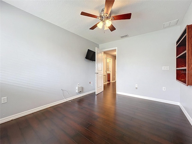empty room featuring ceiling fan, baseboards, dark wood-type flooring, and visible vents