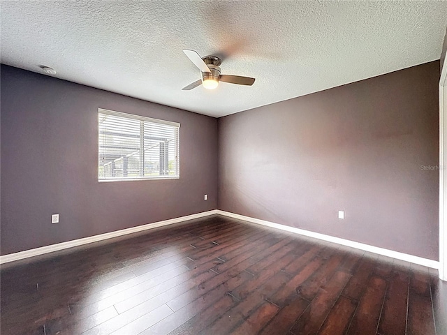 empty room featuring baseboards, a ceiling fan, dark wood-style floors, and a textured ceiling