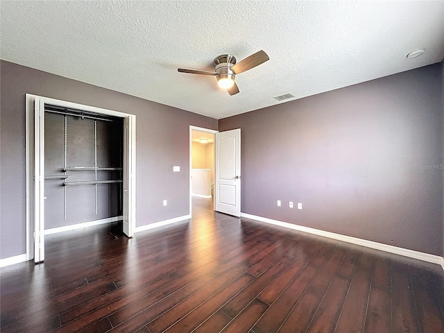 unfurnished bedroom with wood finished floors, baseboards, a textured ceiling, and a closet