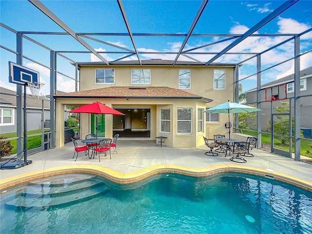 pool featuring outdoor dining area, glass enclosure, and a patio