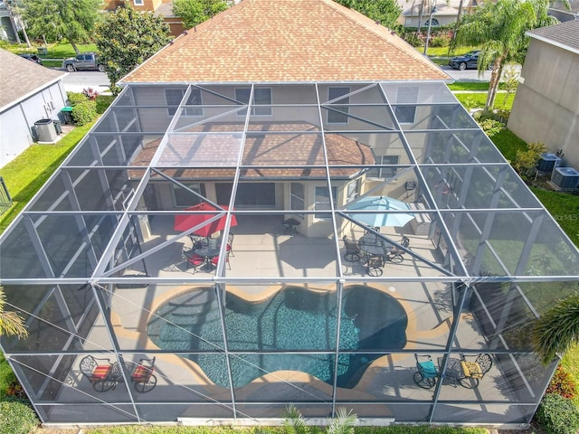 exterior space featuring a pool and a shingled roof