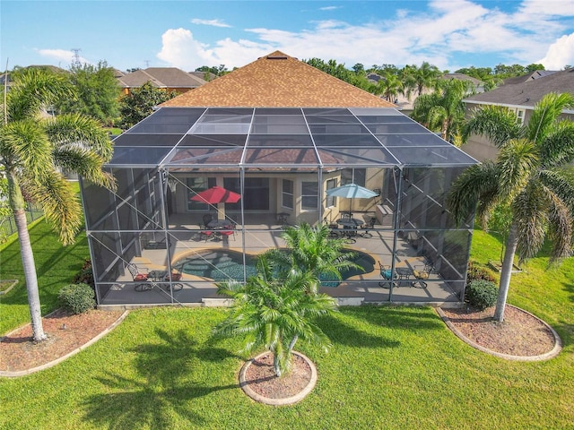 rear view of property featuring a lanai, a yard, an outdoor pool, and a patio area