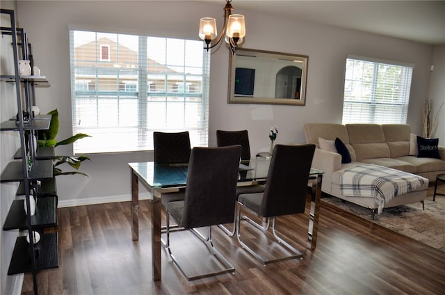3416 Seneca Club Loop Unit 56, Orlando, FL 32808 - dining area featuring wood finished floors, baseboards, and an inviting chandelier