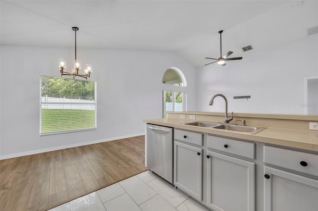 kitchen with decorative light fixtures, visible vents, lofted ceiling, stainless steel dishwasher, and a sink