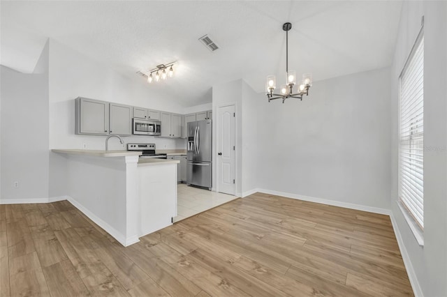 kitchen with gray cabinetry, visible vents, light countertops, stainless steel appliances, and a notable chandelier
