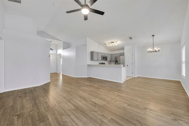 unfurnished living room featuring light wood finished floors, ceiling fan with notable chandelier, visible vents, and vaulted ceiling