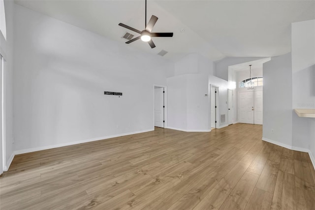 unfurnished living room featuring ceiling fan with notable chandelier, light wood finished floors, baseboards, and visible vents