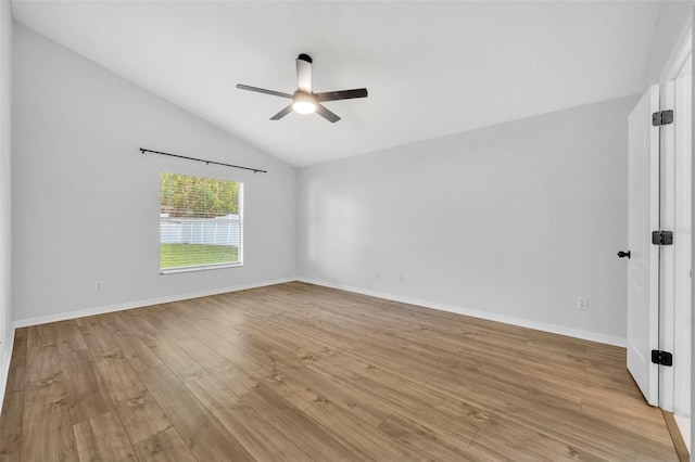 spare room featuring baseboards, light wood-type flooring, a ceiling fan, and lofted ceiling