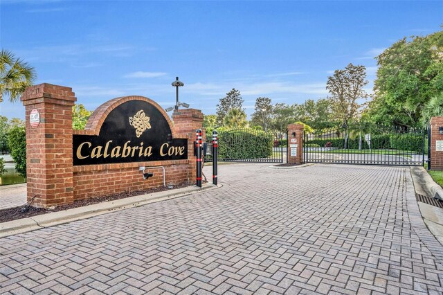 view of street with a gated entry, curbs, and a gate