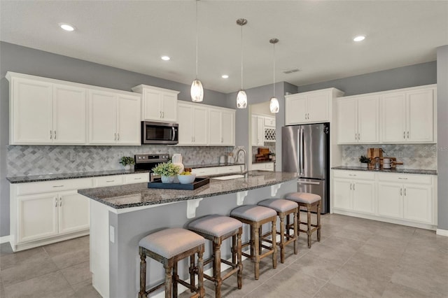 3259 Buoy Cir, Winter Garden, FL 34787 - kitchen featuring appliances with stainless steel finishes, a sink, a center island with sink, a breakfast bar area, and backsplash