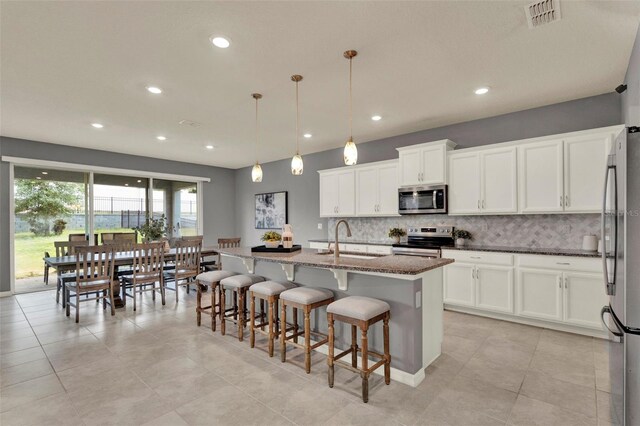 3259 Buoy Cir, Winter Garden, FL 34787 - kitchen featuring visible vents, dark stone counters, decorative backsplash, stainless steel appliances, and a sink