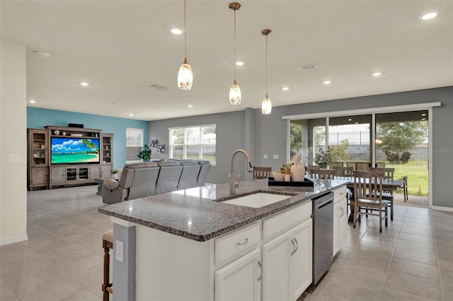 3259 Buoy Cir, Winter Garden, FL 34787 - kitchen with dark stone countertops, dishwasher, a sink, decorative light fixtures, and a center island with sink