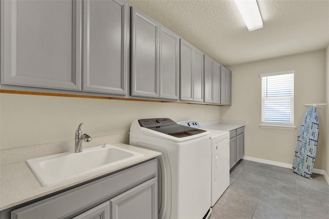 3259 Buoy Cir, Winter Garden, FL 34787 - laundry area featuring a textured ceiling, light tile patterned flooring, a sink, washing machine and dryer, and cabinet space