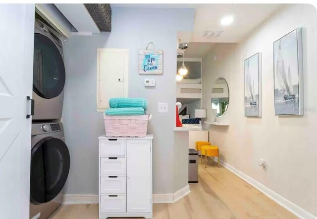 8800 Bay Pines Blvd Unit 306, Saint Petersburg, FL 33709 - clothes washing area featuring light wood finished floors, stacked washer / dryer, laundry area, electric panel, and baseboards