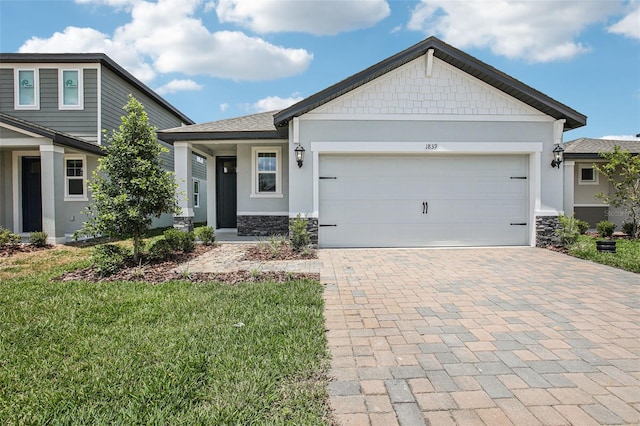 1839 Brekey Way, Zephyrhills, FL 33541 - view of front of house featuring stone siding, decorative driveway, a front yard, and stucco siding