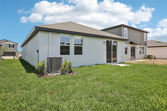1839 Brekey Way, Zephyrhills, FL 33541 - rear view of house featuring central air condition unit, a lawn, roof with shingles, and stucco siding