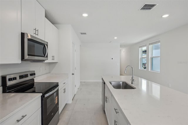 1839 Brekey Way, Zephyrhills, FL 33541 - kitchen with appliances with stainless steel finishes, a sink, light stone counters, recessed lighting, and white cabinets