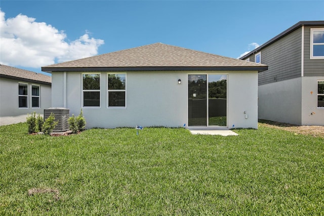1839 Brekey Way, Zephyrhills, FL 33541 - rear view of house featuring cooling unit, stucco siding, a shingled roof, and a lawn