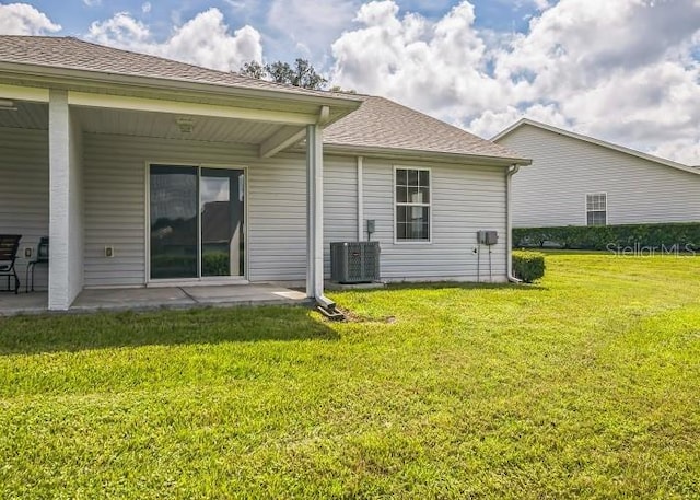 2503 SE 18th Cir, Ocala, FL 34471 - back of house with roof with shingles, a yard, a patio, and cooling unit
