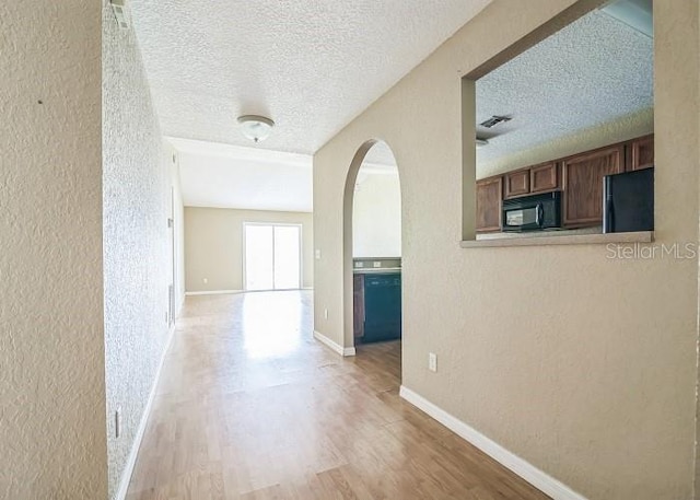 2503 SE 18th Cir, Ocala, FL 34471 - hall with a textured wall, arched walkways, light wood-style flooring, and a textured ceiling
