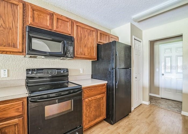 2503 SE 18th Cir, Ocala, FL 34471 - kitchen with brown cabinetry, light wood-type flooring, light countertops, and black appliances