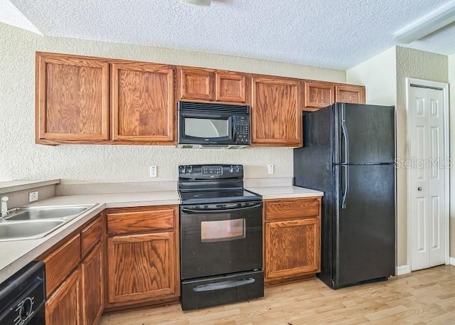 2503 SE 18th Cir, Ocala, FL 34471 - kitchen featuring light countertops, a textured ceiling, black appliances, light wood-style floors, and a sink