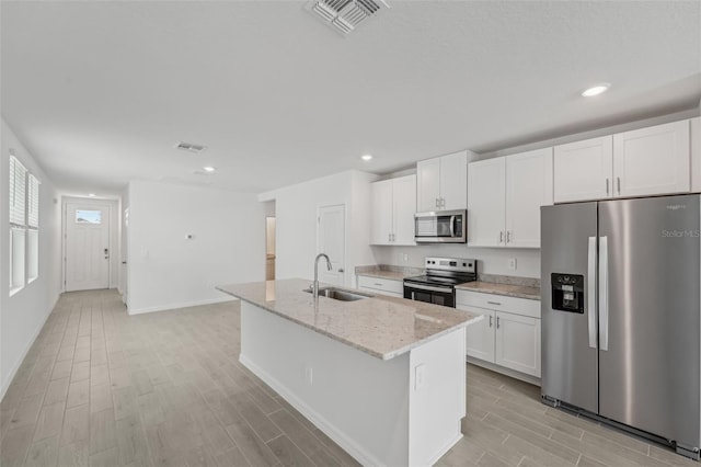 1861 Brekey Way, Zephyrhills, FL 33541 - kitchen featuring stainless steel appliances, a sink, light wood finished floors, white cabinetry, and recessed lighting