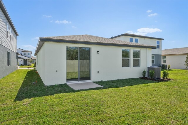 1861 Brekey Way, Zephyrhills, FL 33541 - back of property featuring a lawn, stucco siding, and cooling unit