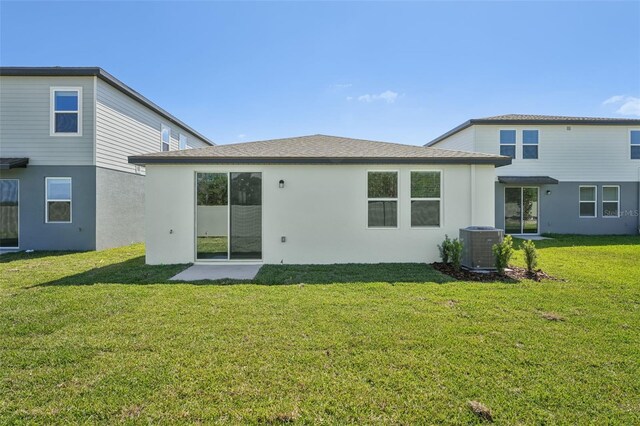 1861 Brekey Way, Zephyrhills, FL 33541 - rear view of property with a lawn, stucco siding, and cooling unit