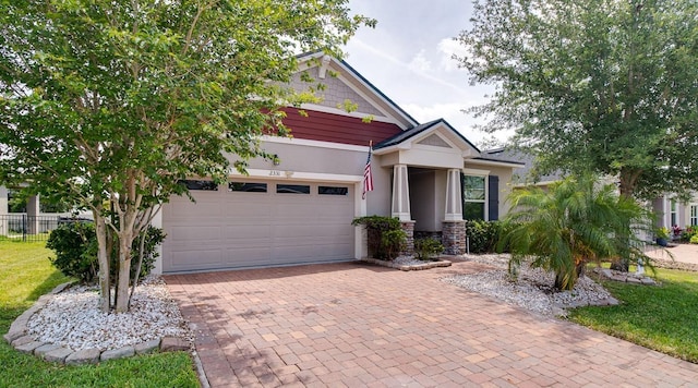 2331 Kennington Cv, Deland, FL 32724 - craftsman inspired home with stone siding, fence, a garage, stucco siding, and decorative driveway