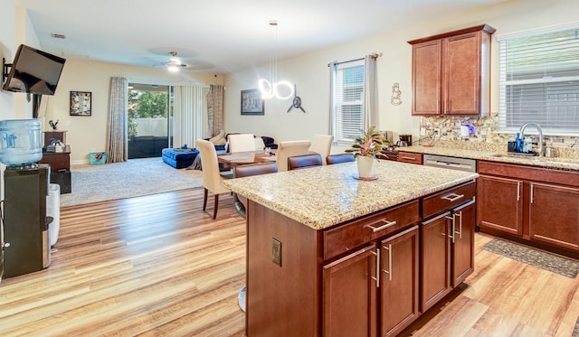 2331 Kennington Cv, Deland, FL 32724 - kitchen featuring light stone counters, open floor plan, light wood-style floors, and a sink
