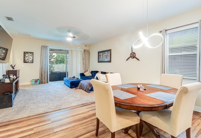 2331 Kennington Cv, Deland, FL 32724 - dining space featuring visible vents, baseboards, wood finished floors, and ceiling fan with notable chandelier