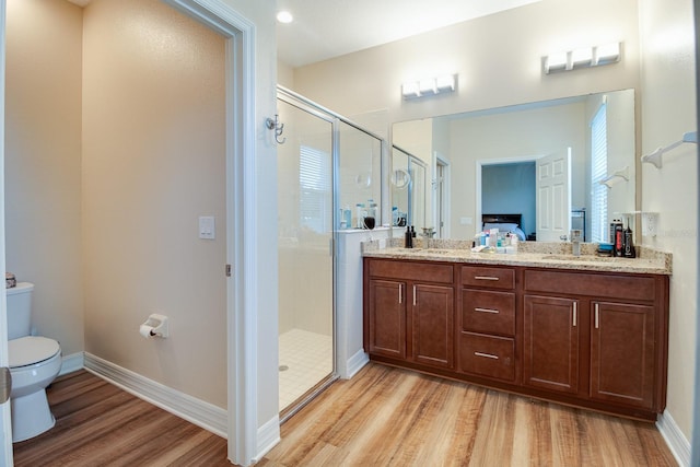 2331 Kennington Cv, Deland, FL 32724 - full bathroom with double vanity, toilet, baseboards, wood finished floors, and a shower stall