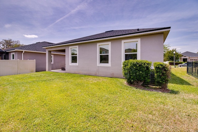 2331 Kennington Cv, Deland, FL 32724 - back of house with stucco siding, a lawn, and fence