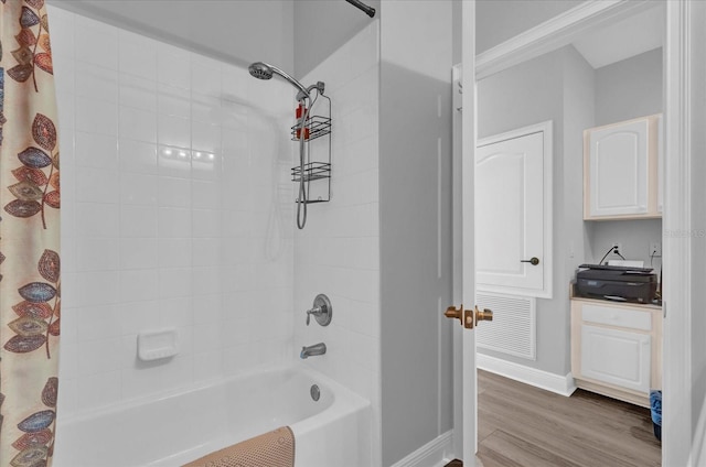 full bathroom with visible vents, baseboards, wood finished floors, and shower / tub combo