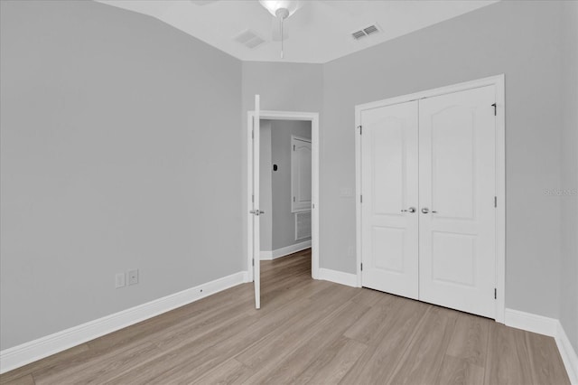 unfurnished bedroom featuring light wood-style floors, baseboards, a closet, and visible vents