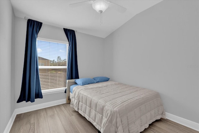 bedroom with baseboards, a ceiling fan, vaulted ceiling, and wood finished floors