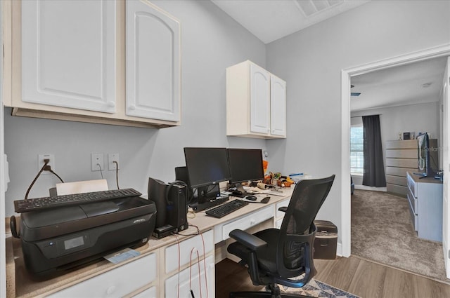 office space featuring baseboards, visible vents, and wood finished floors