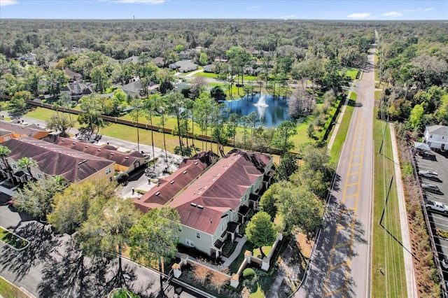 drone / aerial view featuring a water view, a residential view, and a forest view