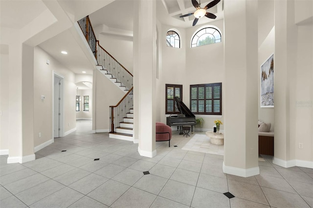 tiled foyer featuring stairway, baseboards, a towering ceiling, ceiling fan, and recessed lighting