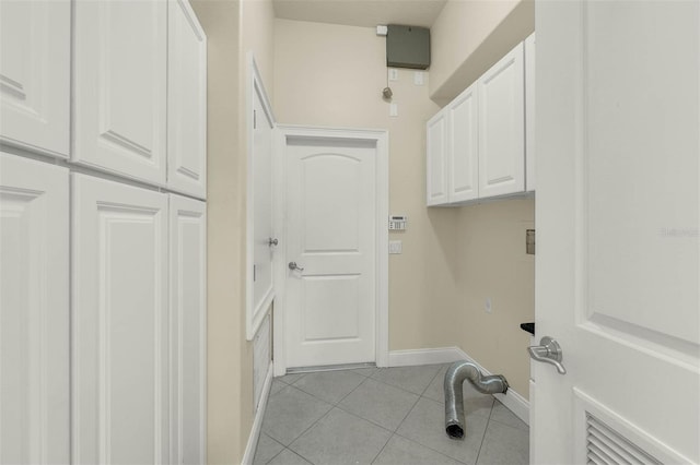 clothes washing area featuring baseboards, light tile patterned flooring, and cabinet space