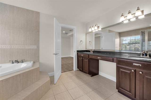 bathroom featuring tile patterned flooring, a garden tub, double vanity, and a sink