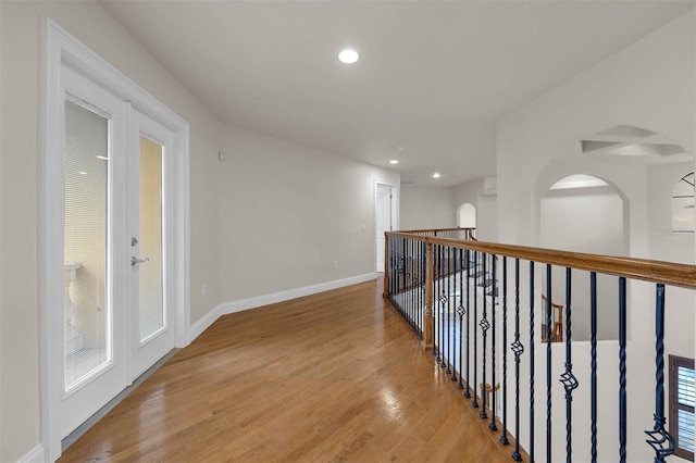 corridor featuring light wood-type flooring, baseboards, and recessed lighting