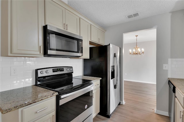 6366 SW 115th Street Rd, Ocala, FL 34476 - kitchen featuring light wood-type flooring, visible vents, a chandelier, appliances with stainless steel finishes, and decorative backsplash