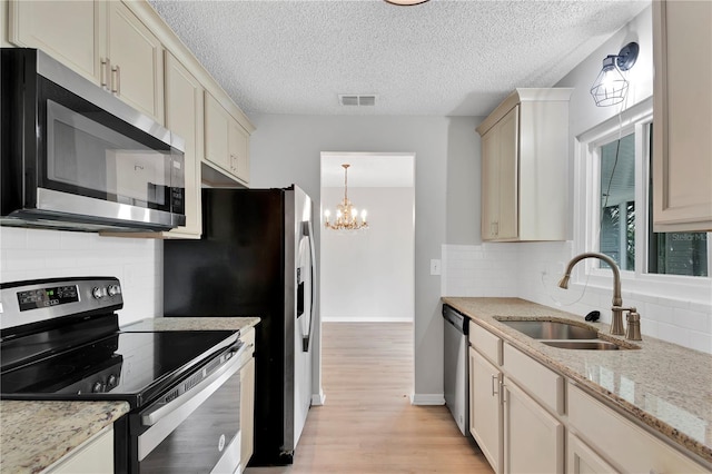 6366 SW 115th Street Rd, Ocala, FL 34476 - kitchen featuring a notable chandelier, backsplash, light wood-style floors, stainless steel appliances, and a sink