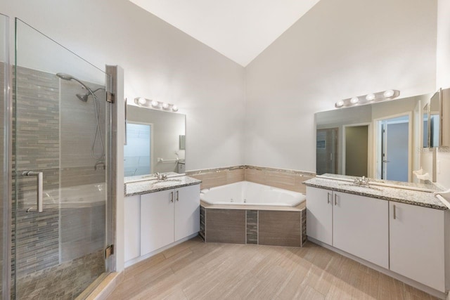 3004 Cottage Grove Ct Unit 1805, Orlando, FL 32822 - full bathroom with vaulted ceiling, a stall shower, two vanities, and a whirlpool tub