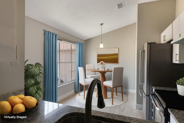 3004 Cottage Grove Ct Unit 1805, Orlando, FL 32822 - dining space with vaulted ceiling, a textured ceiling, and light wood-style flooring