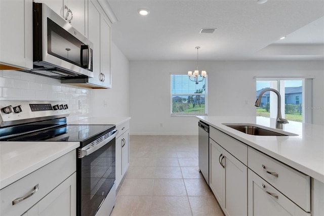10008 Last Light Gln, Parrish, FL 34219 - kitchen featuring visible vents, light countertops, tasteful backsplash, a sink, and appliances with stainless steel finishes