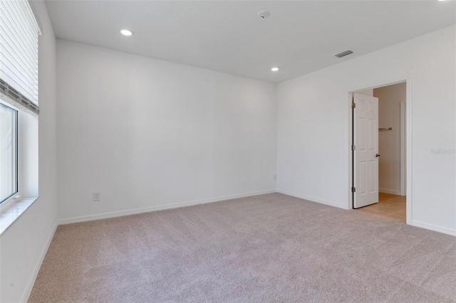 10008 Last Light Gln, Parrish, FL 34219 - empty room with visible vents, baseboards, a healthy amount of sunlight, and light colored carpet