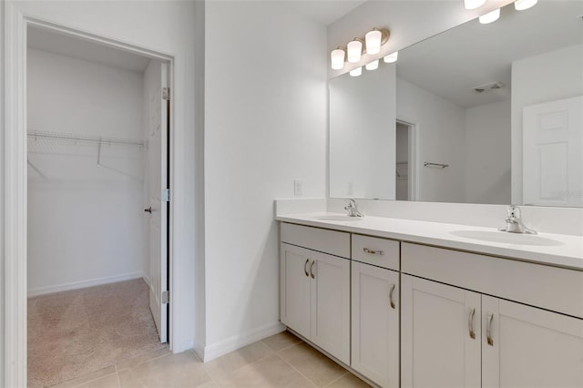 10008 Last Light Gln, Parrish, FL 34219 - bathroom featuring double vanity, a walk in closet, a sink, and tile patterned floors